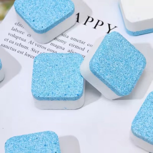 Blauwe, vierkante schoonmaaktabletten op een wit oppervlak met tekst.